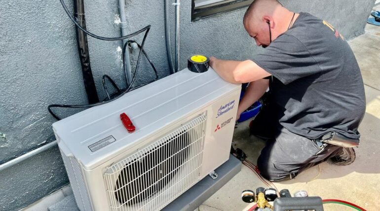 Technician servicing AC unit in Los Angeles home